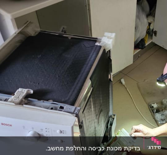 אדם מתקן מדיח כלים במטבח עם פנס ראש